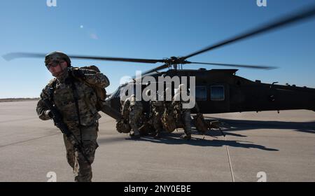 Tech. Sergeant Bradley Hornberger, 22. Sicherheitsgeschwader, Kampfausbildungs- und -Wartungslehrer, und andere Verteidiger verlassen die USA Army UH-60 Blackhawk während gemeinsamer Ausbildung auf der McConnell Air Force Base, Kansas, 3. Februar 2023. Die Airmen trainierten mit den USA Soldaten des 3. Angriffs-Helikopter-Bataillons, 1. Luftfahrtregiment aus Fort Riley, Kansas, um während des Trainings taktische Starts und Landungen im Blackhawk zu üben. Stockfoto