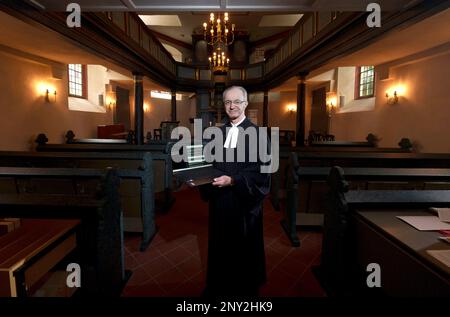 Wiesbaden, Deutschland. 24. Februar 2023. Thomas Hartmann, Pastor der protestantischen Gemeinde Thalkirche, steht mit seinem Computer im historischen Thalkirche. Der Pastor predigt mit ChatGPT (Generative Pre-trained Transformer), einem Chatbot. Ein Chatbot, kurz bot, ist ein textbasiertes Dialogsystem, das das Chatten mit einem technischen System ermöglicht. (An dpa 'Pastor aus Wiesbaden hat Predigten mit ChatGPT geschrieben') Kredit: Andreas Arnold/dpa/Alamy Live News Stockfoto