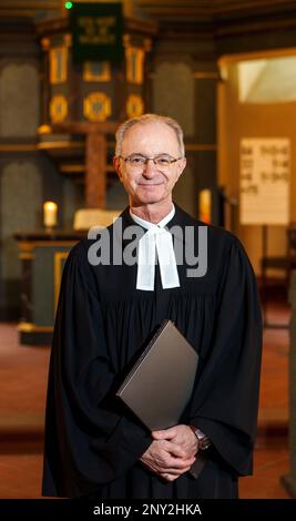 Wiesbaden, Deutschland. 24. Februar 2023. Thomas Hartmann, Pastor der protestantischen Gemeinde Thalkirche, steht mit seinem Computer im historischen Thalkirche. Der Pastor predigt mit ChatGPT (Generative Pre-trained Transformer), einem Chatbot. Ein Chatbot, kurz bot, ist ein textbasiertes Dialogsystem, das das Chatten mit einem technischen System ermöglicht. (An dpa 'Pastor aus Wiesbaden hat Predigten mit ChatGPT geschrieben') Kredit: Andreas Arnold/dpa/Alamy Live News Stockfoto