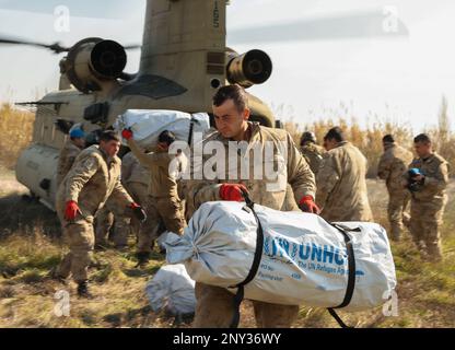 Türkisches Militärpersonal transportiert Hilfsmittel (Zelte) aus den USA Army CH-47 Chinook Helikopter in Kirikhahn, Türkiye, 18. Februar 2023. 1AD CAB bietet eine dynamische Hubkapazität zur direkten Unterstützung der Hilfsmaßnahmen der USAID und der Türkei. 1AD CAB ist eine von mehreren US-Militäreinheiten, die Task Force 61/2 (TF 61/2) unterstützen und unter US-amerikanischer Führung tätig sind Sechste Flotte, USA Marine Forces Europe (NAVEUR) und USA Europäische Befehlshaber sind Teil der internationalen türkischen Katastrophenhilfe. Stockfoto