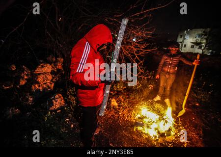 Nablus, Palästina. 01. März 2023. Maskierte Palästinenser, die nachts Holzstöcke um den Feuerstand trugen, bewacht, um Angriffe der jüdischen Siedler südlich von Nablus im Westjordanland abzuwehren. Die Angriffe von Siedlern auf Palästinenser, insbesondere auf Dörfer südlich von Nablus, wie Hawara Burin, nahmen zu. Der letzte davon war in der Stadt Hawara, deren Schaden dem Abbrennen von Dutzenden von Häusern und Geschäften und mehr als hundert Autos gleichkam. Der palästinensische Ministerpräsident Muhammad Shtayyeh erklärte, dass die Gesamtverluste auf fast $5 Millionen Euro geschätzt würden. Kredit: SOPA Images Limited/Alamy Live News Stockfoto