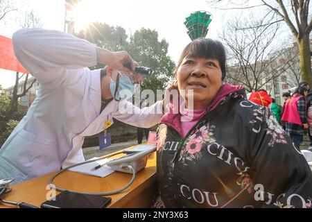 HUZHOU, CHINA - 2. MÄRZ 2023 - Ein medizinischer Freiwilliger überprüft einen Einwohner in Wuyang Community, Wuyang Street, Deqing County, Huzhou Stadt, Ostchina ZH Stockfoto