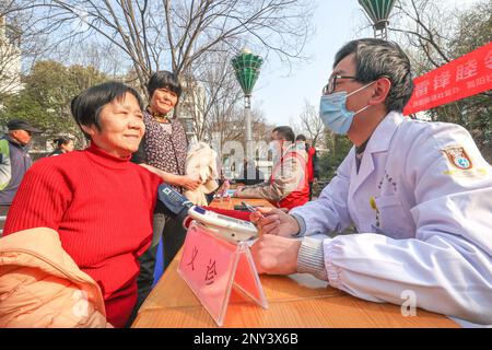 HUZHOU, CHINA - 2. MÄRZ 2023 - Ein medizinischer Freiwilliger misst den Blutdruck eines Einwohners in der Wuyang Gemeinde, Wuyang Unterbezirk, Deqing County, Huz Stockfoto