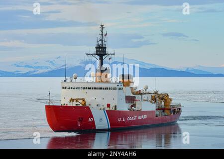 Der schwere Eisbrecher USCGC Polar Star (WAGB 10) bricht das Eis auf und nähert sich der McMurdo Station in der Antarktis. Gemeinsame Task Force — Support Forces Antarctica (JTF-SFA), überwacht die Aktivitäten der gemeinsamen Dienste und unterstützt die National Science Foundation (NSF) und das United States Antarctic Program (USAP) durch die Operation Deep Freeze durch das Verteidigungsministerium. Stockfoto