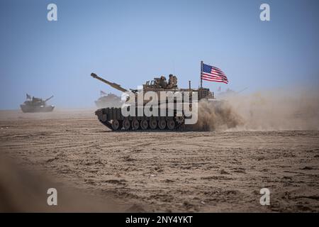Eine M1A2 Abrams-Panzerbesatzung, dem 2-116. Combined Arms Bataillon zugeteilt, geht während der Übung Al Tahreer in Camp Buehring, Kuwait, 20. Februar 2023, in einen Abschusspunkt. Al Tahreer war eine trilaterale Übung mit mehreren Bereichen, als Land- und Luftwaffe zusammenarbeiteten, um Ziele mit Feldartillerie, Luftangriffen und Bodenunterstützung zu neutralisieren. Die Fähigkeit der Koalition, wie Al Tahreer eine kombinierte Feuerübung mit Waffen effektiv durchzuführen, ist ein Beleg für die Führungsstärke und Professionalität der beteiligten Mitglieder. (USA Armeefoto von SPC. David Campos-Contreras) Stockfoto