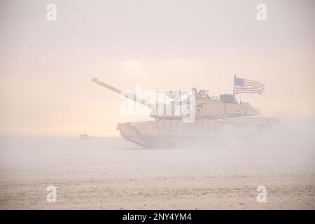 Eine M1A2-Panzercrew von Abrams, dem 2-116. Combined Arms Bataillon zugeteilt, bewegt sich während der Übung Al Tahreer als Teil eines Konvois in Camp Buehring, Kuwait, 20. Februar 2023. Al Tahreer war eine trilaterale Übung mit mehreren Bereichen, als Land- und Luftwaffe zusammenarbeiteten, um Ziele mit Feldartillerie, Luftangriffen und Bodenunterstützung zu neutralisieren. Die Fähigkeit der Koalition, wie Al Tahreer eine kombinierte Feuerübung mit Waffen effektiv durchzuführen, ist ein Beleg für die Führungsstärke und Professionalität der beteiligten Mitglieder. (USA Armeefoto von SPC. David Campos-Contreras) Stockfoto