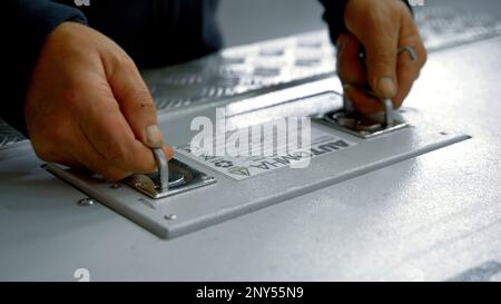 Männerhände. Kreativ.Hände, die eine gefährliche Substanz in einem speziell verpackten geschlossenen Eisenbehälter herausnehmen. Hochwertige 4K-Aufnahmen Stockfoto