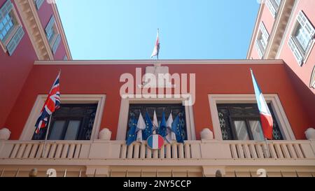 Das Regierungsgebäude in Frankreich. Aktion. Ein kleines rotes Gebäude, dekoriert mit Flaggen am blauen Himmel von oben. Hochwertige 4K-Aufnahmen Stockfoto