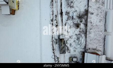 Frachttransport.Clip. Winterliche Aufnahme der Rennstrecke aus einer Höhe auf riesigen beladenen Autos neben Zäunen. Hochwertige FullHD-Aufnahmen Stockfoto