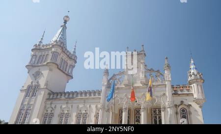 Das große weiße Regierungsgebäude. Aktion. Ein riesiges Gebäude in einem neuen Stil wie ein Palast mit drei Flaggen und einem blauen Himmel. Hochwertige 4K-Aufnahmen Stockfoto