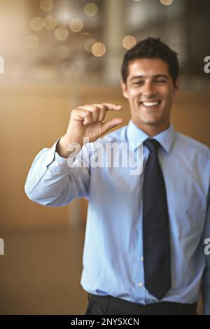 Dynamit ist in kleinen Packungen erhältlich. Ein Geschäftsmann, der eine kleine Geste mit der Hand macht. Stockfoto