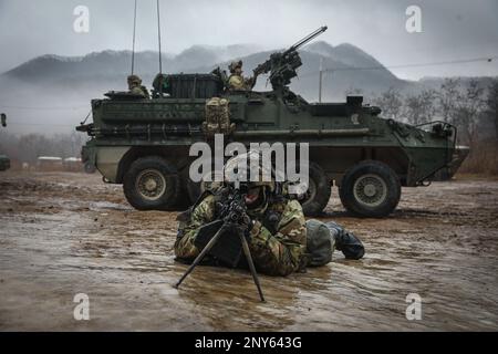 Ein Maschinengewehrschütze des 1. Bataillons, 17. Infanterieregiment, 2. Stryker-Brigaden-Kampfteam, 2. Infanterie-Division zieht Sicherheitsleute aus einem M1126. Stryker-Kampffahrzeug während einer Truppenübung am 13. Januar. 2023 auf dem Twin Bridges Trainingsgelände in Südkorea während der koreanischen Rotationstruppe 12. Stockfoto