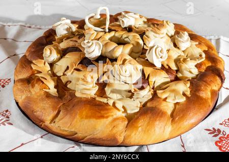 Brot liegt auf Stickerei. Laib-Hochzeitstorte Nahaufnahme auf hellem Hintergrund Stockfoto