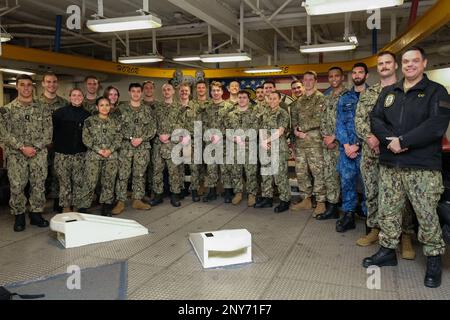 SAN DIEGO (16. Februar 2023) Studenten des Basic Division Officer Course (BDOC), einschließlich Nachwuchsoffiziere, die am Personal Exchange Program der chilenischen und der belgischen Marine teilnehmen, posieren für ein Gruppenfoto mit Reiseleitern und Kapitän Matthew Cieslukowski, Befehlshaber der USS Boxer (LHD 4), Auf der Fo'c'sle während einer Schiffsrundfahrt. Die Studenten besichtigten das Pilotgebäude, das Kampfinformationszentrum und die Deck- und Technikräume. Sie wurden über Schadensbegrenzung, Verantwortlichkeiten von Divisionsoffizieren und allgemeine Seemannschaft informiert. Die Erstausbildung für Offiziere der oberirdischen Kriegsführung, BDOC p Stockfoto