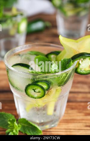 Würziger Cocktail mit Jalapeno, Karambola und Minze auf Holztisch, Nahaufnahme Stockfoto