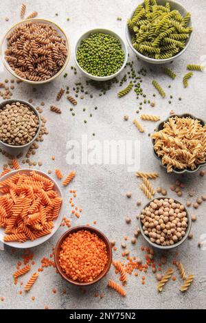 Eine Auswahl an Fusilli-Pasta aus verschiedenen Arten von Hülsenfrüchten, grünen und roten Linsen, Mungbohnen und Kichererbsen. Glutenfreie Pasta. Stockfoto