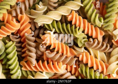 Eine Auswahl an Fusilli-Pasta aus verschiedenen Arten von Hülsenfrüchten, grünen und roten Linsen, Mungbohnen und Kichererbsen. Glutenfreie Pasta. Lebensmittelhintergrund Stockfoto