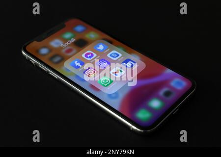 MYKOLAIV, UKRAINE - 09. AUGUST 2021: Smartphone mit Social-Media-Apps-Symbolen auf dem Bildschirm vor schwarzem Hintergrund Stockfoto