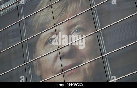 A picture of German chancellor Angela Merkel can be seen behind the glass panes of the CDU headquarters in Berlin, Germany, Saturday, Sept. 23, 2017 one day ahead of the German Federal elections. (Michael Kappeler/dpa via AP)