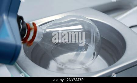 Nahaufnahme des Mechanismus mit rotierendem sauberen Glaskolben. Aktie-Aufnahmen. Medizinische oder chemische Laborausrüstung Stockfoto