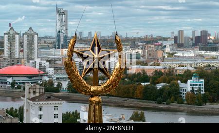 Luftaufnahme eines Gebäudeteils, historisches Element eines Dachs. Aktie-Aufnahmen. Goldener Turm mit Stern der UdSSR im Hintergrund einer Stadt Stockfoto