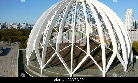 Luftaufnahme eines ungewöhnlichen Gebäudes mit einer kugelförmigen Struktur, die wie eine Kuppel aussieht. Aktie-Aufnahmen. Architekturkonzept Stockfoto
