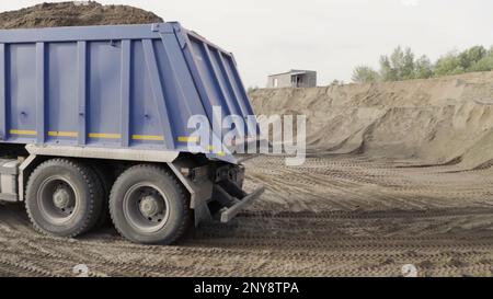 Bergbau-Müllwagen, der im Sandbruch arbeitet. Szene. Industrieller Hintergrund im Steinbruch oder auf der Baustelle Stockfoto