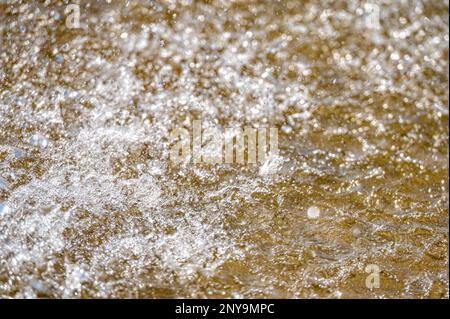 Wasser spritzt mit kleinen Tropfen in den Brunnen. Abstrakter natürlicher, selektiver Fokus-Hintergrund Stockfoto