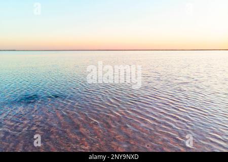 Rosa Salzsee im Reservat. See, wo das Wasser rosa ist. Ungewöhnliche Orte auf dem Planeten. Naturhintergrund mit Rosenwasser im Salzsee. Stockfoto