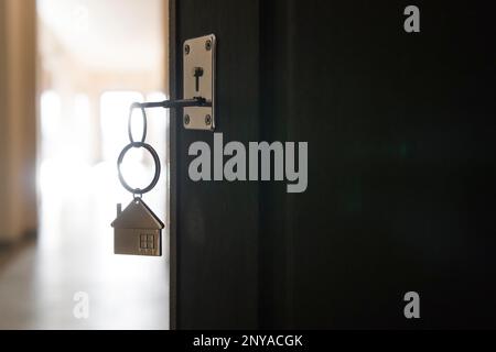 Öffnen Sie die vordere Tür der Wohnung. Haus Modell und Schlüssel im Haus Tür. Immobilienmakler bieten Haus, Sachversicherung und Sicherheit, Stockfoto