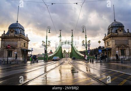 Freiheits- oder Freiheitsbrücke in Budapest nach dem Regen. Die alte grüne Brücke verbindet Buda und Pest über die Donau. Budapest, Ungarn - 2. Februar 2023. Stockfoto