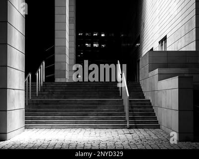 Moderne städtische Gebäude bei Nacht, moderne Stadtarchitektur, Schwarzweißfoto. Städtischer Raum, keine Menschen Stockfoto