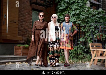 Schöne Frauen mittleren Alters, die auf der Straße spazieren gehen. Ältere Modemodelle in stilvoller Kleidung. Street-Style. Reife Freundinnen, die das Leben genießen Stockfoto