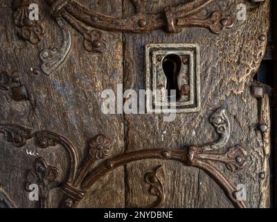 Nahaufnahme des Schlosses und Ziermetallarbeiten an der Eichentür aus dem 13. Jahrhundert der All Saints Church, Turvey, Bedfordshire, Großbritannien. Stockfoto