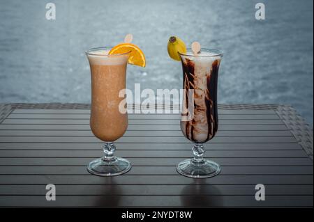Cocktail mit Orange und Banane. Zwei Gläser Cocktails auf dem Tisch im Restaurant. Stockfoto