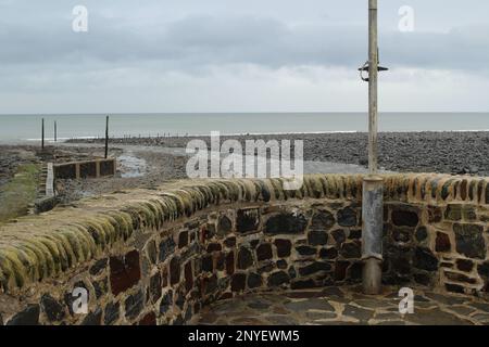 LYNMOUTH, DEVON, Großbritannien - 29. JANUAR 2017 Lynmouth Harbour Sea Wall mit Blick auf das Meer am Strand an einem nebligen Tag Stockfoto