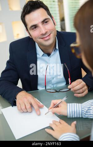 Hübscher junger lächelnder Mann im Optikgeschäft Stockfoto