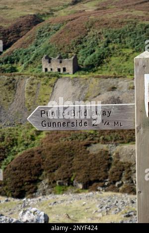 Hölzerner Wegweiser für den öffentlichen Bridleway nach Gunnerside in der Nähe des Old Bunton Level Lead in Gunnerside Gill, Swaledale, Yorkshire Dales National Park, Großbritannien. Stockfoto