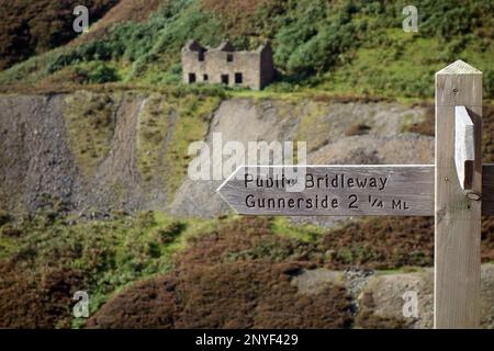 Hölzerner Wegweiser für den öffentlichen Bridleway nach Gunnerside in der Nähe des Old Bunton Level Lead in Gunnerside Gill, Swaledale, Yorkshire Dales National Park, Großbritannien. Stockfoto