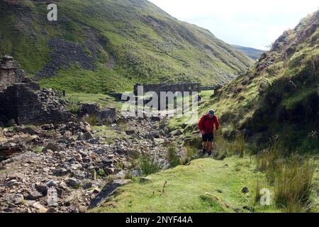 Ein Mann, der Blind Gill von der Blakethwaite Smelt Mill hochgeht, von Gunnerside Beck in Swaledale, Yorkshire Dales National Park, Yorkshire, England, Großbritannien Stockfoto