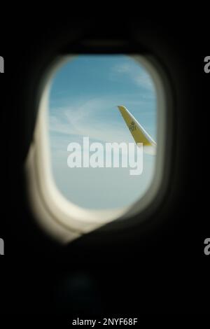 Foto aus dem Inneren des Flugzeugs mit Blick aus dem Fenster mit dem Logo von Royal Brunei Airlines auf dem Flügel Stockfoto