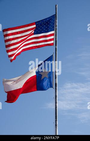 US-Flagge und Texas-Bundesflagge an einem Fahnenmast im Wind, Texas, USA. Stockfoto