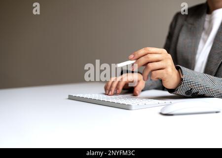 Weibliche Geschäftsfrau, die einen digitalen Stift in der Hand hält und einen virtuellen Vertrag unterzeichnet. Stockfoto