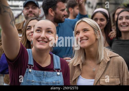 „Eine vielfältige Gruppe von Freunden, die ein Selfie im Freien, bei einem Konzert, einer Party oder einem Rave machen. Zwei Mädchen fallen auf, eine mit blondem Haar und die andere mit einem Non Stockfoto