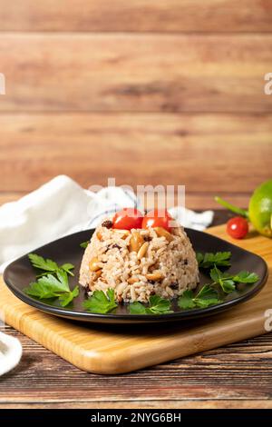 Mandelreis. Türkische Köstlichkeiten. Reis mit schwarzem Pfeffer, Zimt, Nelkenpfeffer, Johannisbeeren, Mandeln und Reis. Ramadan-Essen. Lokaler Name: Ic pila Stockfoto