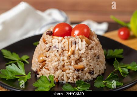 Mandelreis. Türkische Köstlichkeiten. Reis mit schwarzem Pfeffer, Zimt, Nelkenpfeffer, Johannisbeeren, Mandeln und Reis. Ramadan-Essen. Lokaler Name: Ic pila Stockfoto