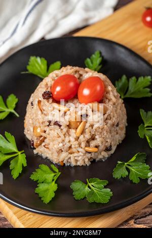 Mandelreis. Türkische Köstlichkeiten. Reis mit schwarzem Pfeffer, Zimt, Nelkenpfeffer, Johannisbeeren, Mandeln und Reis. Ramadan-Essen. Lokaler Name: Ic pila Stockfoto