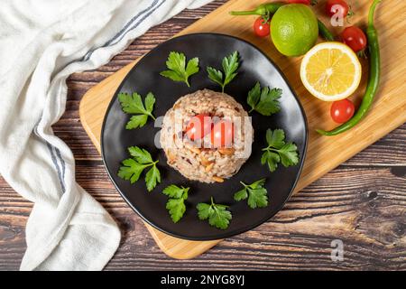 Mandelreis. Türkische Köstlichkeiten. Reis mit schwarzem Pfeffer, Zimt, Nelkenpfeffer, Johannisbeeren, Mandeln und Reis. Ramadan-Essen. Lokaler Name: Ic pila Stockfoto