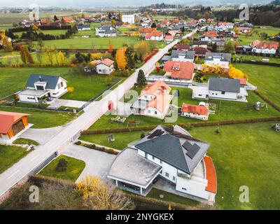 Luftaufnahme der kleinen Vorstadtgemeinde außerhalb der Stadt, Familienhäuser auf beiden Seiten der Straße Stockfoto