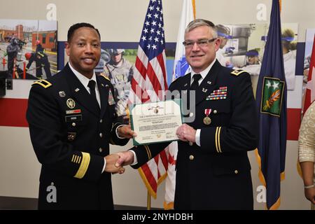 Brigg. Gen. Daryl O. Hood (links), kommandierender General des 20. Kommandos für chemische, biologische, radiologische, nukleare und explosive Stoffe (CBRNE), Überreicht Major William J. Cook III (rechts) die Meritorious Service Medal während seiner Ruhestandsfeier auf dem Aberdeen Proving Ground, Maryland, 21. Februar. Cook schloss seine 20-jährige Karriere als Kommandorichter Advocate am CBRNE-Kommando 20. ab. USA Armeefoto von Angel D. Martinez-Navedo. Stockfoto